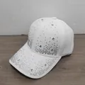 Primer plano de una gorra de béisbol blanca con estrellas de diamantes de imitación. - Blanco