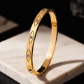 Gros plan d'un bracelet en acier doré orné de motifs d'yeux sertis de pierres colorées. - Œil protecteur / Doré