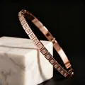 Primer plano de un brazalete de acero inoxidable oro rosa con engastes cuadrados de cristal. - Estilo Cuadros (44-C-6) / Especificación Estándar / Rosa oro / 0.9