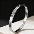 Detailed macro view of silver titanium steel bangle with sparkling star and crystal accents - Steel Color Eight-Pointed Star Zirconia Bangle / Silver