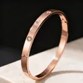Close-up detail of a rose gold titanium steel bangle featuring engraved star and zircon stones - Rose Gold Eight-Pointed Star Zirconia Bangle / Rose Gold