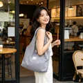 Modella asiatica con borsa tote grigia capiente in un ambiente di caffè rilassato - Grigio Chiaro a Pois