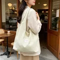 Modella asiatica che indossa una borsa tote beige a pois in un bar - Giallo Chiaro a Pois