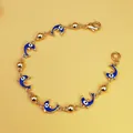 Dettaglio del bracciale dorato stile oceano con ciondoli a delfino blu e malocchio - Stile Delfino Blu (B001)
