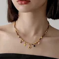 Collana bohémien stile Maillard con ciondoli a sole e stella dorati su una modella - Collana Occhio di Tigre Stella Girasole