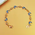 Dettaglio di un bracciale bohémien dorato con ciondoli a forma di delfino blu nazar. - Stile Delfino Blu Scuro (B003)