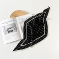 Dettaglio di un foulard in seta plissettata a pois bianchi e neri su una rivista - 70cm / Pois Neri