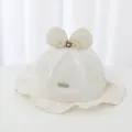 Close-up detail of a white baby lace fisherman hat featuring a bow and floral embroidery - 45-48cm / Beige