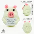 Detail view of a handmade crochet pig doll with positive quote card and size marks. - White Pig