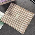 Detail view of a soft brown and white houndstooth pattern scarf with delicate fringe edges. - Small Houndstooth Pattern / Khaki / Over 175cm
