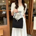 Elegante schwarze Cord-Einkaufstasche mit geblümtem Knotengriff, von Modell gehalten - Schwarz