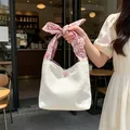 Detailansicht der weißen strukturierten Handtasche mit rosa geblümter Schleife - Weiß