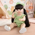Full view of reborn baby doll in green checkered clothes sitting in a cozy playroom setting - Green Plaid Romper Brown Hair / Doll Clothes (Outfit Only)