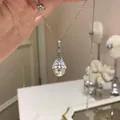 Gros plan détaillé d'un collier de perles élégant avec un pendentif en dentelle serti. - Style 43 (Argent Dentelle Strass Perle) / Argent