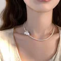 Gros plan d'un élégant collier ras du cou en perles avec pendentifs fleurs blanches délicats - Style 48 (Argent Blanc Perle Fleur 3D) / Argent
