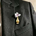 Kreative goldene Vasen-Brosche an einem schwarzen Anzugrevers mit einer kleinen Blume - Goldimitat Kreativer Vasenstil (11846) / Gold