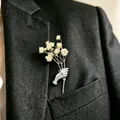 Kreative silberfarbene Brosche in Handform mit Blumenstrauß an einem schwarzen Anzugrevers - Realistischer Handgriff-Stil (WG-0997) / Silber