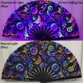 UV fluorescent folding fan with butterfly pattern shown under blacklight and natural light - Floral Butterfly UV Glow A81