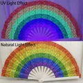 Rainbow sequin folding fan with bamboo ribs shown under UV light and natural light - Rainbow Sequin UV Glow A74