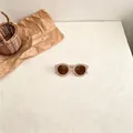 Close-up of stylish retro checkered children's sunglasses featuring brown lenses - Colorful Checkerboard