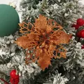 Close-up of golden glittery poinsettia flower decoration on a snowy Christmas tree. - Antique Bronze