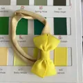 Handmade yellow bow headband for babies with high elasticity displayed on a professional color chart. - Bright Yellow