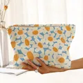 Une main tenant une trousse de maquillage en velours côtelé avec motif floral dessiné - Beige Bleu Orange Géométrique (AC51234)