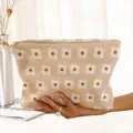 Detailed view of a hand holding a beige floral corduroy makeup bag with zipper - Beige Purple Floral (JX165204)