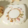 Dettaglio della cavigliera bohémien dorata con conchiglie naturali e ciondolo pesce - 32254-ank-pw
