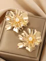 Elegant gold floral statement earrings featuring a large central pearl accent piece - Gold