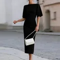 Detail view of an elegant black boat-neck slim-fit midi dress in a street setting - 3XL / Black