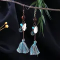 Bohemian tassel drop earrings with turquoise beads and shells displayed on a rustic branch - Wood Bead Shell Mixed Tassel Style (E2403-1)