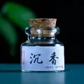 Traditional handmade natural agarwood incense pills in a small glass jar with cork lid - Agarwood Scent (Dry Pills)