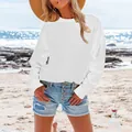 Detail view of a loose white long sleeve fleece sweatshirt for women on a sunny beach - S / White