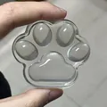 Detailed view of a clear cat paw squishy toy made of jelly wax being held by a human hand - Cat Paw Style / Clear
