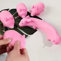 Detailed macro view of pink pig-shaped squishy stress relief toys being stretched by hand - Stretchy Pig Stress Toy