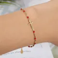 Elegante bracciale a croce d'oro con perline rosse su una catena delicata per donne e damigelle. - Placcato Oro Rosso