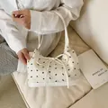 Cremefarbene Schultertasche mit schwarzen Schleifenmustern und großer Mittelschleife - Beige