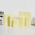 Premium pale yellow kraft paper gift bags with white twisted handles available in various sizes - Macaroni Yellow; Vertical Style Extra Small Size (12*15*6)