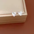 Close-up of sparkling heart-shaped zircon stud earrings on jewelry box - Stud Earrings / Silver Needle / White