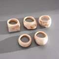Detailed view of 5 chunky resin rings with cream marble pattern on leather surface - 5 Pieces / Beige