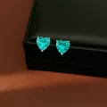 Close-up view of elegant heart-shaped turquoise zircon stud earrings on black display - Stud Earrings / Silver Needle / Green