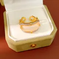 Detail shot of a gold zircon ring with pink sugar cube stone in a green velvet box - Square Sugar Hollow Style (HR3527) / Gold