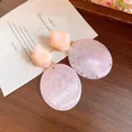 Detailed close-up of pink marble resin earrings featuring vintage geometric drop shapes - Purple