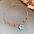 Detailed view of vintage gold-tone necklace with a blue floral pendant and bead accents - Necklace - Gold - Blue