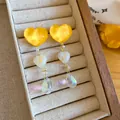 Close-up of yellow resin heart earrings with marbled beads and iridescent teardrops - Irregular Heart Tassel (HE34255) / Yellow-White