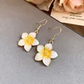 Macro detail showing the elegant yellow and white enamel flower drop earrings set - Ear Hooks - Gold - White