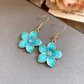 Detail view of turquoise enamel flower dangle earrings in vintage gold-tone finish - Gold-Blue Hook Style