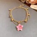 Detail of golden double-layer anklet with pink enamel cherry blossom pendant - Anklet-Gold-Pink