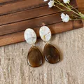 Close-up of vintage resin drop earrings with elegant brown and white marbled texture - Coffee-White